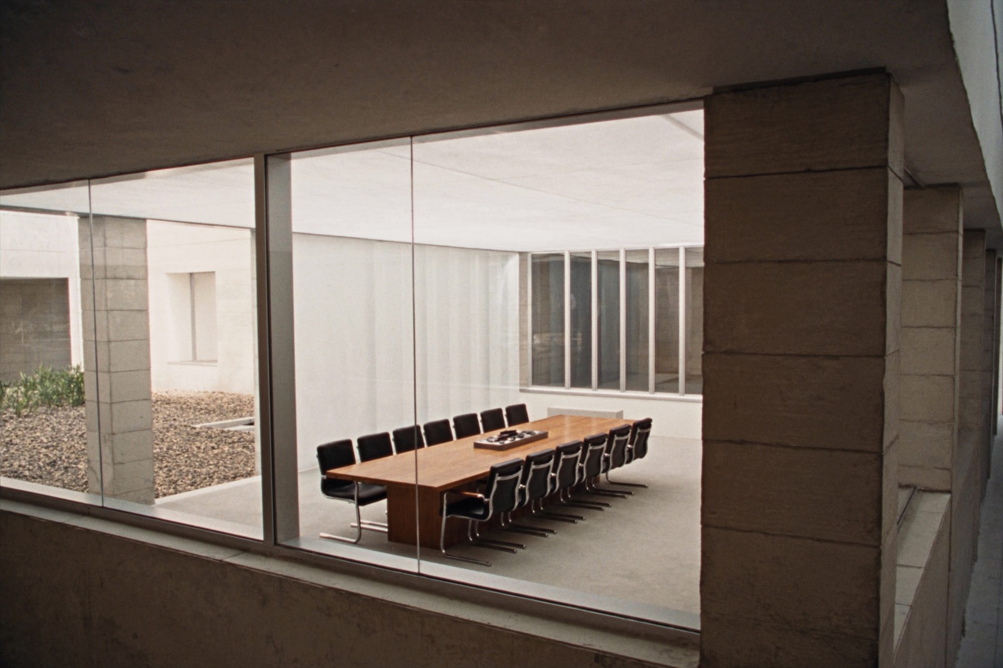 Conference room with a long oak table and black leather chairs