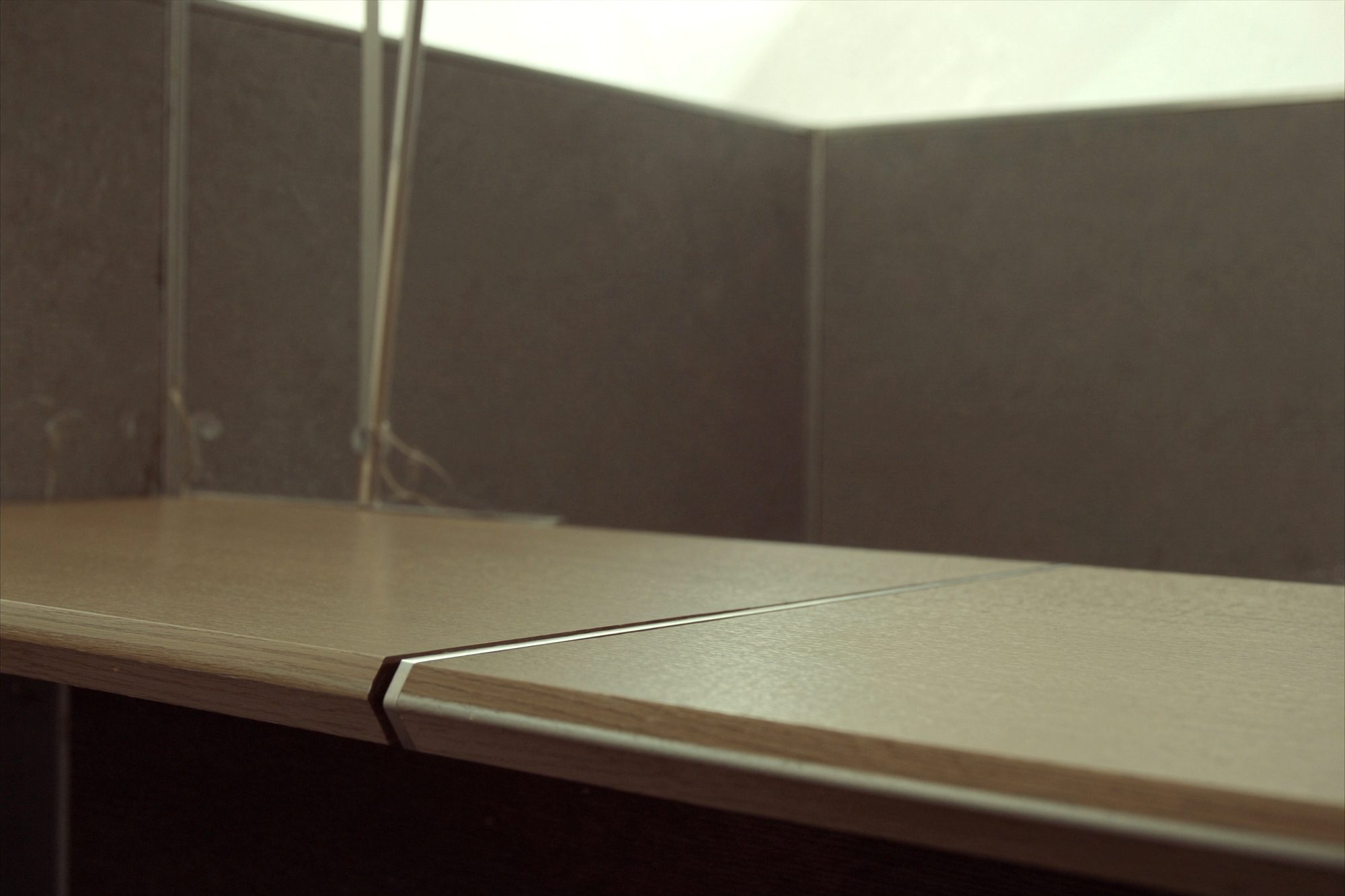 Detail of a benching workstation edge with a monitor arm and felt screen